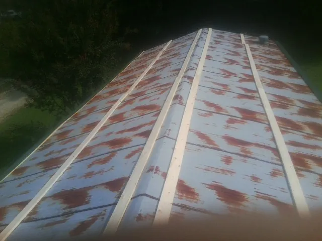 Rusted metal roof panels with new wood purlins before replacement — Storm Damage Roof Repair in Eagan by Roofing Brothers