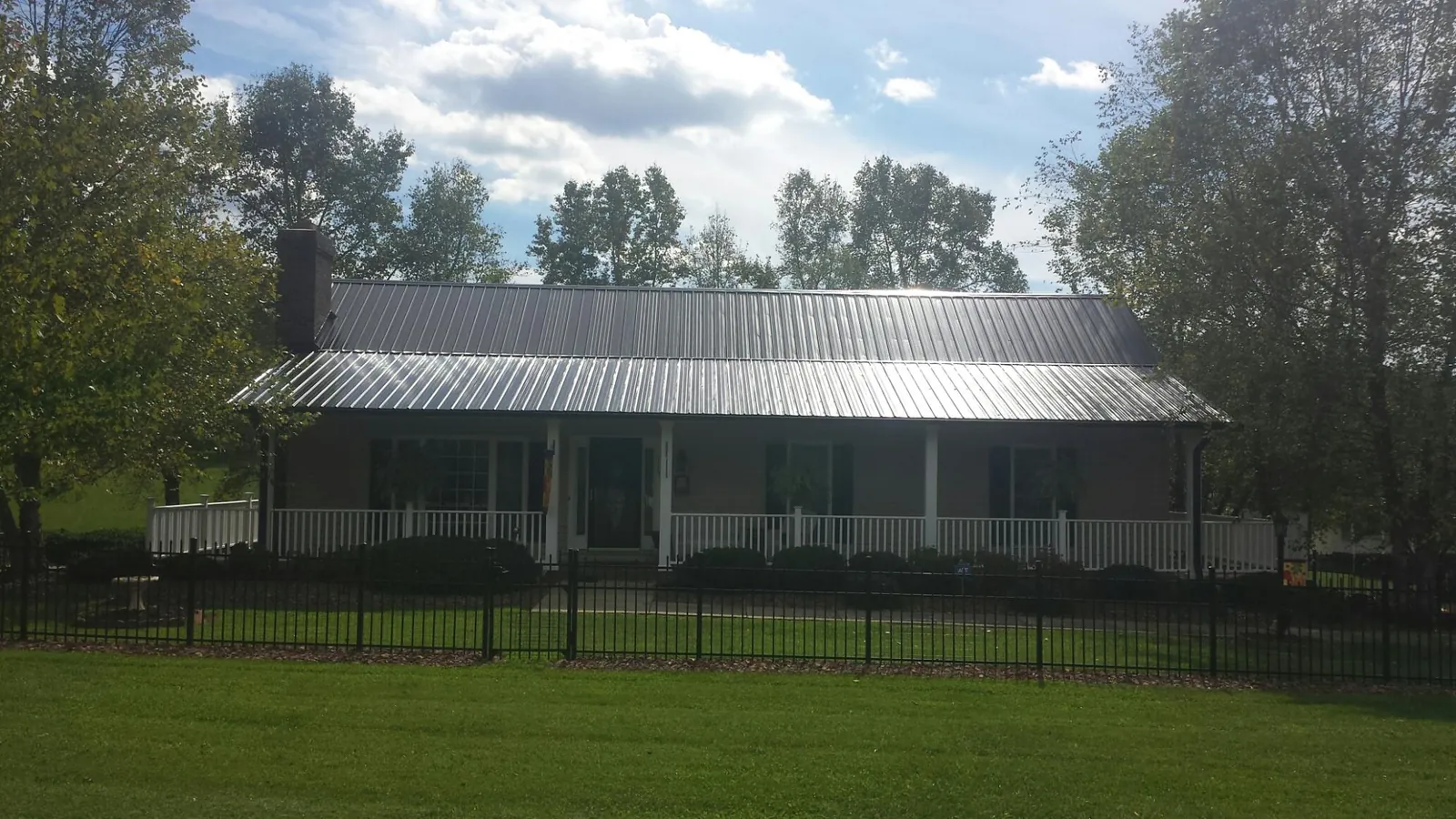 Gray metal roof on a brick ranch with a full width front porch — Gutter Guard Installation work by our crew in Eagan